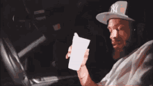 a man wearing a ny hat holds a cup