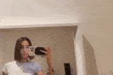 a woman is taking a selfie with her phone in a mirror