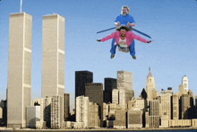 a man and a woman are flying over a city in front of the twin towers