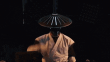 a man wearing a chinese hat is playing a dj set