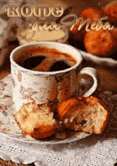 a cup of coffee sits on a saucer next to a bite taken out of a croissant
