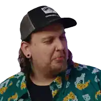 a man wearing a hat and a green shirt with a leaf print