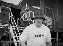 a man wearing a levi 's t-shirt is standing in front of a camera
