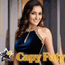 a woman in a blue dress is smiling in front of a microphone with the name capy fatty written on the bottom .