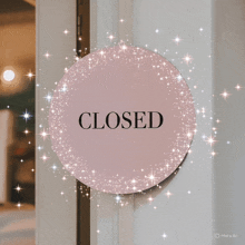 a closed sign is surrounded by sparkly stars