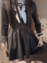 a girl in a black dress with a white bow on the front