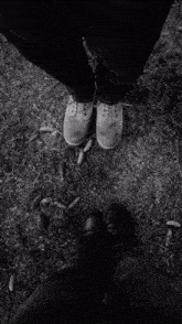 a black and white photo of a person 's feet in the grass