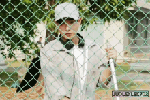 a man standing behind a chain link fence with judleklek702 written on the bottom