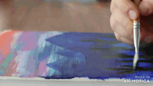 a person is painting with a brush on a piece of paper that says made in animatica on the bottom