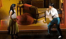 a man and a woman are dancing on a stage in a room
