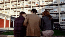 a group of people are sitting in front of a large building