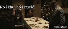 a man in a suit stands in front of a table with plates and a candle on it