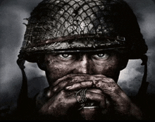 a black and white photo of a soldier with his hands on his mouth