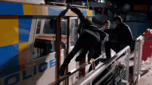 a group of people are getting off a police boat at night