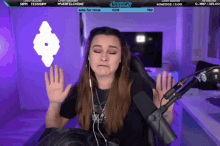 a woman is sitting in front of a microphone with a screen that says sorry emily on it