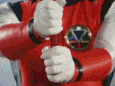 a close up of a person holding a red object in their hand .
