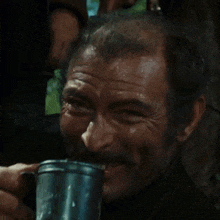 a man drinking from a metal mug with his mouth open