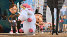 a stuffed unicorn with a pink mane and horn is being held by a girl
