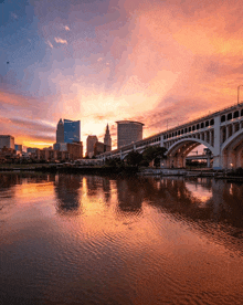 a bridge over a body of water in front of a city skyline