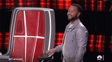 a man is standing in front of a machine that says the voice