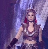 a woman with red hair is wearing a costume with horns on it .