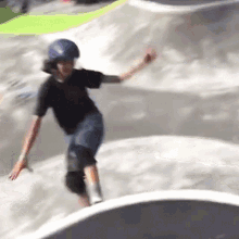 a young boy wearing a helmet is riding a skateboard down a ramp