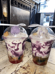 two cups of ice cream with spoons in them