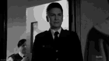 a man in a suit and tie is standing in a doorway with the word soho on the bottom right