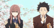a boy and a girl are standing next to each other in front of a tree with flowers .