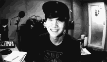 a man wearing a black shirt that says obey is smiling