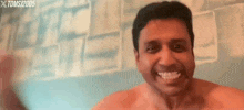 a shirtless man is smiling in front of a wall with the year 2005 on it