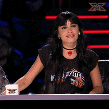 a woman wearing a t-shirt that says foo fighters is smiling