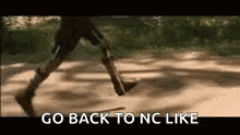 a person is walking down a dirt road with the words `` go back to nc like '' written on it .