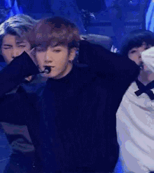 a man with a microphone in his mouth is dancing on stage