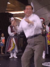 a man in a white shirt is dancing in a crowd