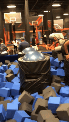 a group of people are playing in a trampoline park and one of them is wearing a number 13 jersey