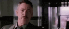 a man in a suit and tie is making a funny face .