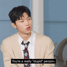a man wearing a cardigan and tie says you 're a really " stupid " person