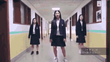 a girl in a school uniform is standing in a hallway