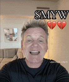 a man in a black shirt is smiling in front of two broken hearts and the words smyw