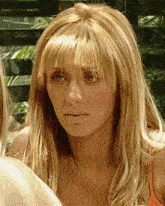 a close up of a woman 's face with blonde hair and bangs