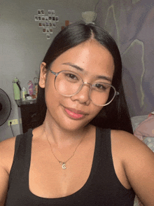 a woman wearing glasses and a necklace with the letter g
