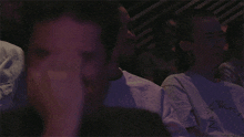 a man in a black shirt is laughing while sitting at a table
