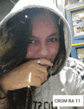 a woman wearing a hooded sweatshirt with the word crom on it
