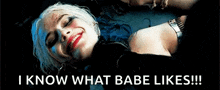 harley quinn from suicide squad is laying on the floor and smiling .