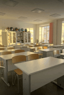 a classroom with tables and chairs and globe displays
