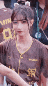 a girl wearing a d-link jersey with a bun in her hair