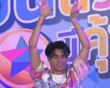 a man with his arms in the air stands in front of a sign that says jc