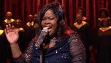 a woman singing into a microphone on a stage
