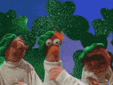 three muppets wearing green hats and sweaters are standing next to each other